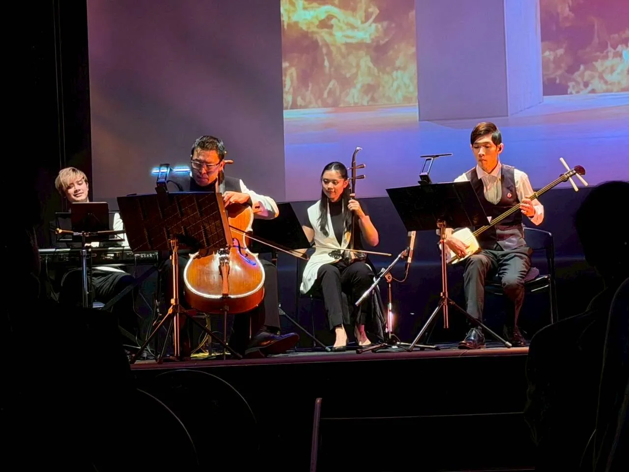 KIKUCHI Mitsutaka performing shamisen on stage alongside fellow musicians